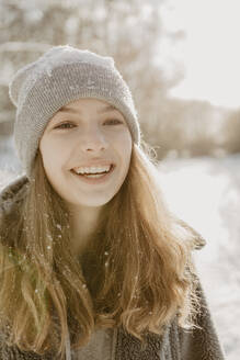 Porträt eines schönen Mädchens mit Strickmütze, das in die Kamera lächelt - OJF00423