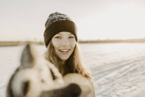 Porträt eines schönen Mädchens mit Strickmütze, das sich der Kamera nähert - OJF00431