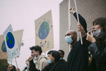 Male and female activist protesting for environmental issues during pandemic - MASF22153