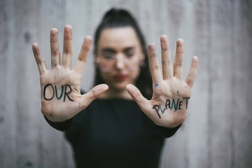 Our planet text written on palms of female activist - MASF22162