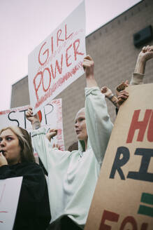 Junge Demonstrantinnen mit Girl-Power-Schild in der sozialen Bewegung - MASF22182