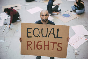 Bald man with equal rights sign standing in building - MASF22201