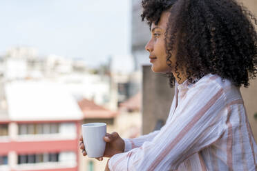 Contemplating female entrepreneur in balcony during coffee break at office - AFVF08425