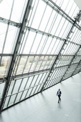 Male business professional walking in corridor - GUSF05330