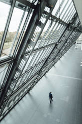 Male entrepreneur walking in corridor at office - GUSF05395