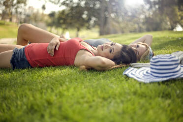 Junge Frauen im Gras liegend im Park - AJOF01172