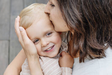 Close up of mother hugging and kissing her little son - OGF00927