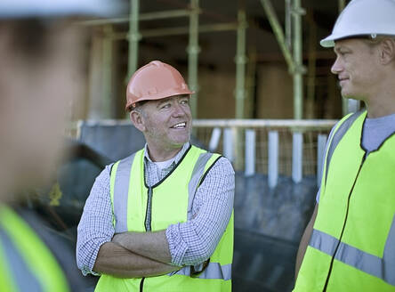 Two male construction workers talking outdoors - AJOF01179