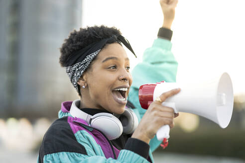 Young woman doing announcement through megaphone - JCCMF01331