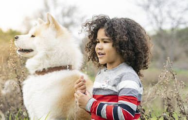 Boy looking away by dog in nature - JCCMF01344