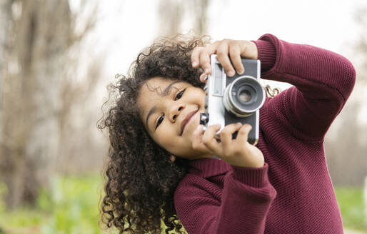 Niedlicher Junge hält Vintage-Kamera in der Natur - JCCMF01350