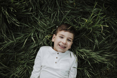 Junge lächelnd im Gras liegend - GMLF01074