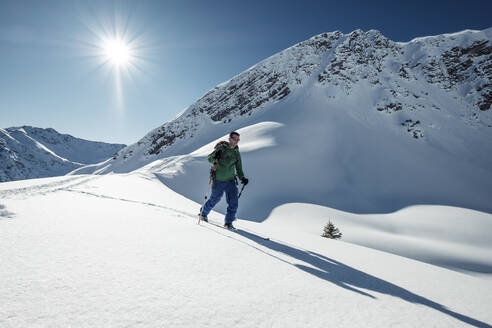 Man ski touring on snowcapped Steinkarspitze, Lechtal Alps, Tyrol, Austria - WFF00492