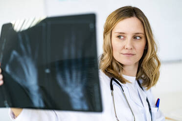 Radiologin bei der Untersuchung von Röntgenbildern in einer medizinischen Klinik - GIOF11616
