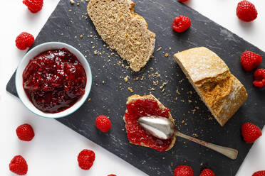 Brotscheiben, frische Himbeeren und eine Schale Himbeermarmelade - IFRF00441