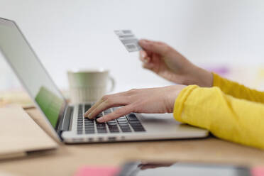 Frau zahlt mit Kreditkarte vom Laptop zu Hause - EIF00546