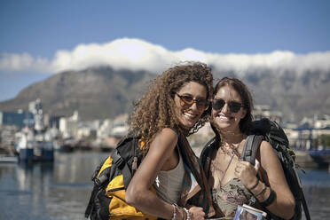 Cheerful female tourists with backpacks on sunny day - AJOF01223