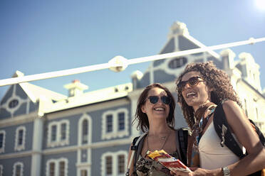 Female friends enjoying city break on sunny day - AJOF01224