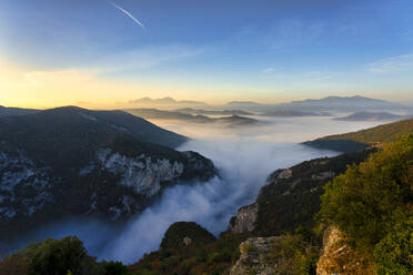 In Nebel gehüllte Berge vor blauem Himmel bei Sonnenaufgang in der Furlo-Schlucht, Marken, Italien - LOMF01241