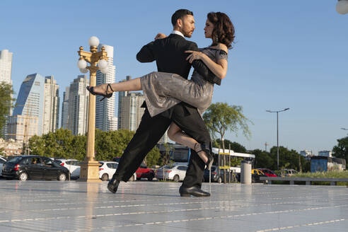 Male and female dancers looking at each other while practicing Tango dance on footpath - SPCF01255