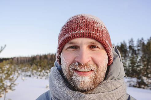 Mittlerer Erwachsener mit verschneitem Gesicht im Winter - EYAF01525