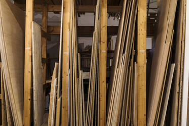 Wooden planks at rack in workshop - VABF04258