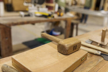 Holzhammer auf Kiste an Werkbank in der Industrie - VABF04260