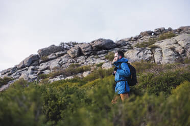 Männlicher Wanderer inmitten von Pflanzen in Somosierra, Madrid, Spanien - RSGF00583