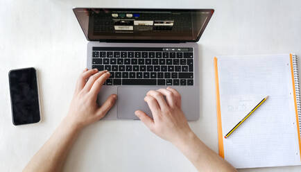 Man using laptop on desk at home office - MGOF04669