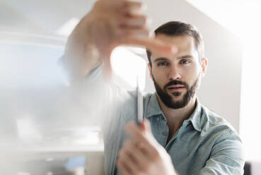 Businessman gesturing while working at office - DIGF14944