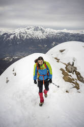 Alpinist walking with hiking pole on snowcapped mountain - MCVF00734