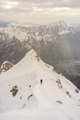 Trekker walking on snowcapped mountain against beautiful mountain range - MCVF00740