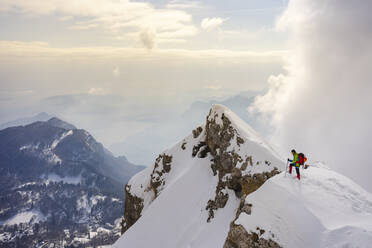 Mountain climber walking on mountain peak against sky - MCVF00745