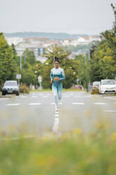 Young sportswoman running on street - MTBF00886