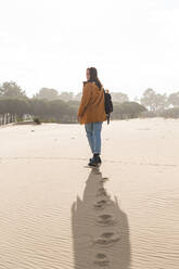 Fußabdrücke einer jungen Frau beim Spaziergang am Strand - JAQF00354
