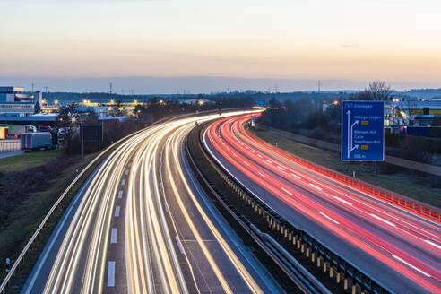 Deutschland, Baden-Württemberg, Fahrzeug-Lichtspuren auf der A81 in der Abenddämmerung - WDF06543