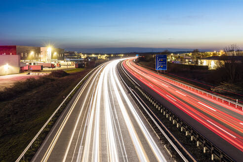 Deutschland, Baden-Württemberg, Fahrzeug-Lichtspuren auf der A 81 in der Abenddämmerung - WDF06544