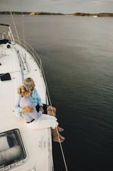 High angle view of senior couple admiring sea while sitting on boat - MASF22301