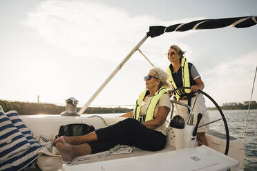 Fröhliche ältere Freundinnen im Boot an einem sonnigen Tag - MASF22327