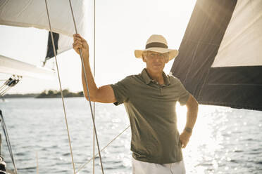 Porträt eines älteren Mannes, der ein Seil hält, während er an einem sonnigen Tag im Meer steht - MASF22337
