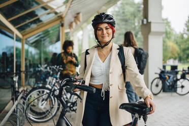 Porträt einer Studentin mit Fahrrad auf dem Universitätscampus - MASF22435