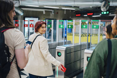 Porträt einer jungen Studentin, die in einer U-Bahn-Station über die Schulter schaut - MASF22446