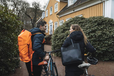 Smiling couple walking with bicycle at back yard - MASF22508