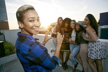 A group of young women partying on a city rooftop at dusk - MINF16102