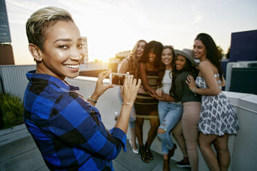 A group of young women partying on a city rooftop at dusk - MINF16103