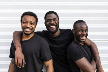 Inhalt beste afroamerikanische Freunde in schwarzen T-Shirts, die eng beieinander stehen und in die Kamera schauen, auf hellem Hintergrund - ADSF21124