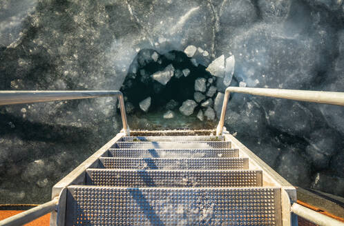 Looking Down The Frozen Steps Of A Ladder Into Ice Blocks in Denmark - CAVF93670