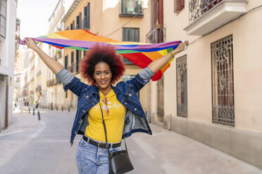 Frau mit Afro-Haar trägt Homosexuell Stolz Flagge - CAVF93698