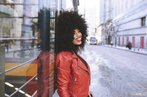 Fill Körper Seitenansicht von selbstbewussten afroamerikanischen Frau mit Afro-Frisur auf dem Bürgersteig stehen und schauen weg - ADSF21161