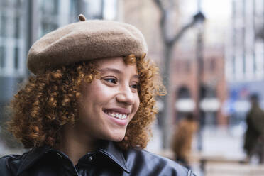 Smiling teenage girl wearing beret looking away while standing outdoors - PNAF00931